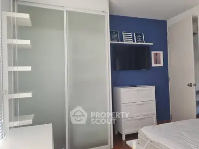 Modern bedroom with sliding closet doors and blue accent wall