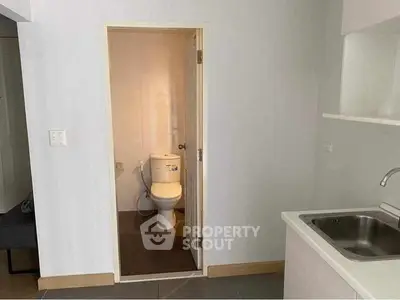 Compact apartment with small bathroom and kitchenette, ideal for urban living.