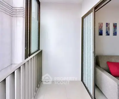 Modern apartment balcony with sliding glass doors and cozy interior view.