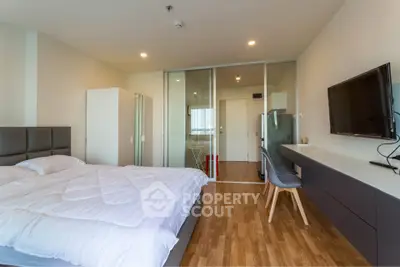 Modern bedroom with sleek design, featuring a comfortable bed, wall-mounted TV, and stylish wooden flooring.
