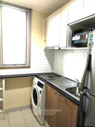 Modern kitchen with washing machine and stainless steel appliances