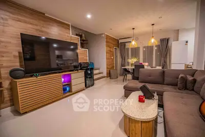 Modern living room with large TV, stylish furniture, and ambient lighting