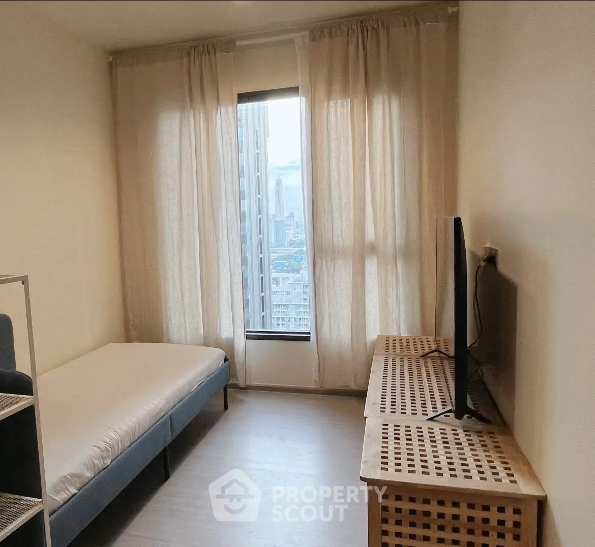 Cozy bedroom with city view, featuring a single bed and modern TV setup.