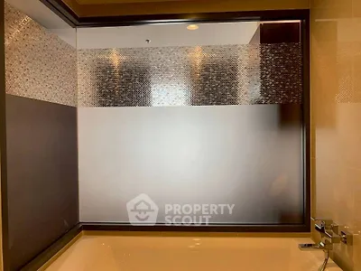 Elegant bathroom with modern frosted glass shower enclosure and sleek fixtures.