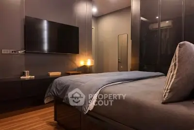 Modern bedroom with sleek design and wall-mounted TV, perfect for relaxation.