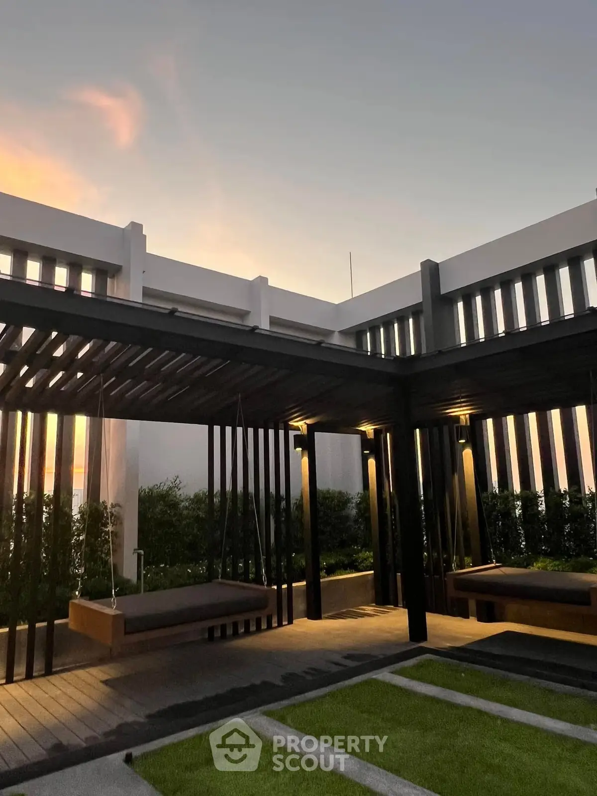 Modern outdoor terrace with stylish pergola and ambient lighting at sunset.