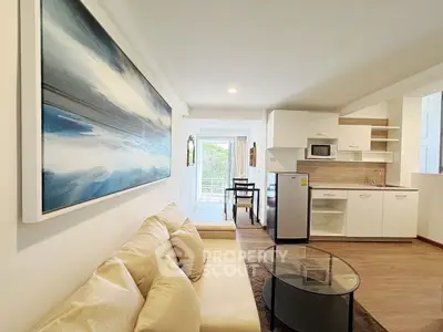 Modern open-plan living room with kitchenette and balcony view
