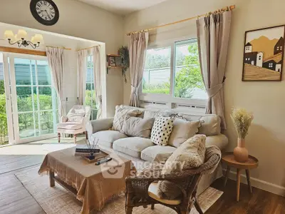 Charming living room with cozy seating and abundant natural light, perfect for relaxation and entertaining.