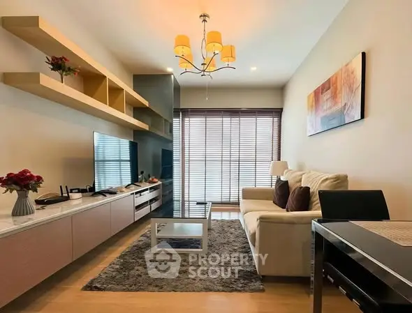 Modern living room with stylish decor, cozy seating, and natural light from large windows.