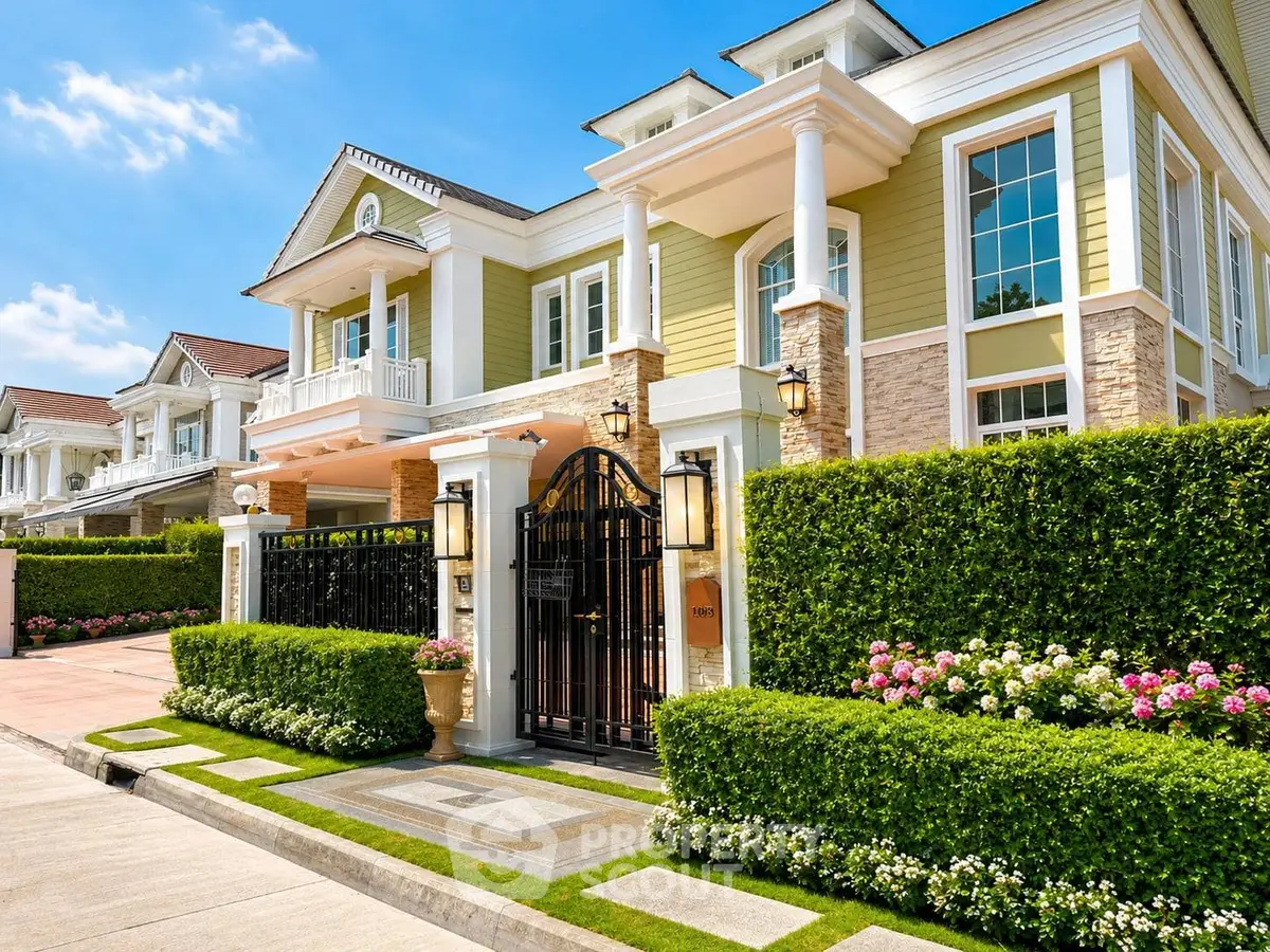 Luxurious two-story house with elegant facade, lush garden, and gated entrance in a prestigious neighborhood.