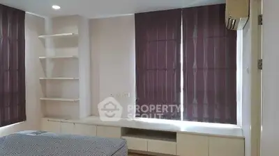 Modern bedroom with built-in shelves and air conditioning, featuring sleek design and ample natural light.