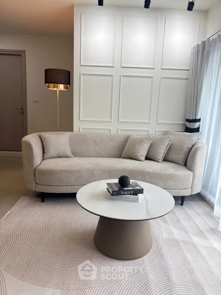 Elegant living room with modern beige sofa and stylish round coffee table, perfect for cozy gatherings.
