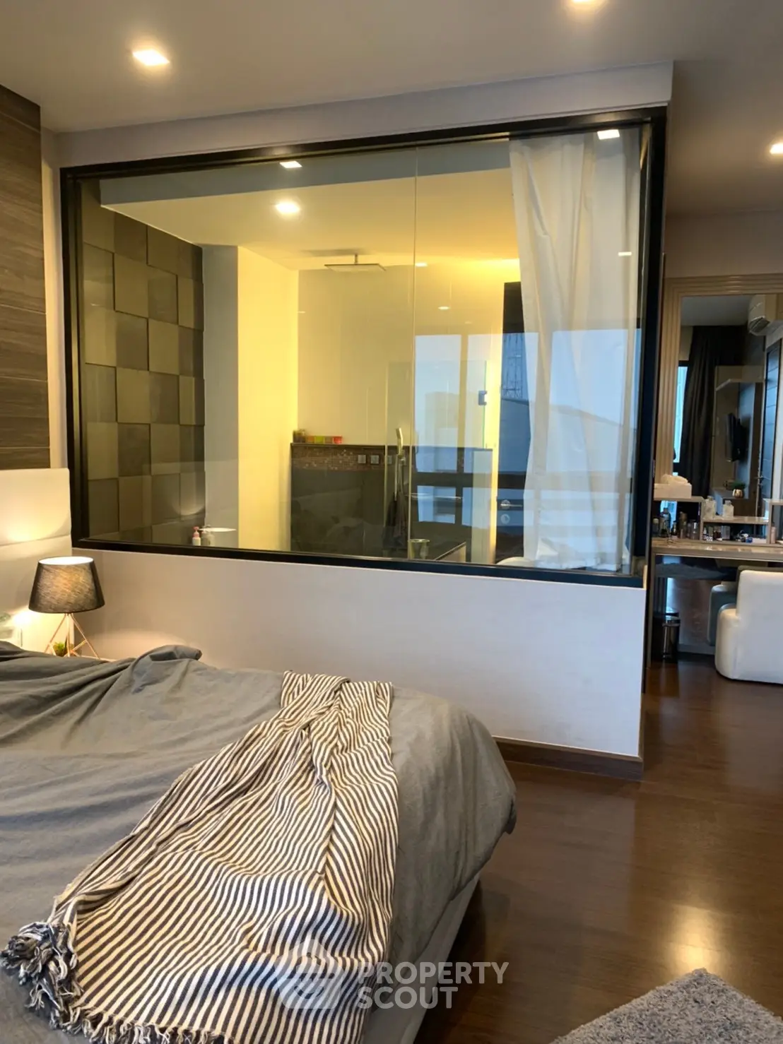 Luxurious bedroom with glass wall bathroom and modern decor
