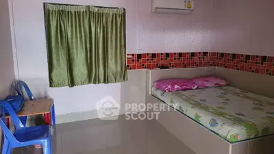 Cozy bedroom with colorful bedding and simple furnishings, ideal for a comfortable living space.