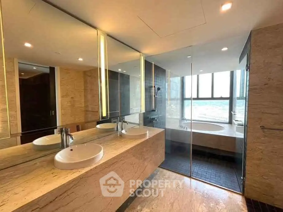 Luxurious bathroom with modern fixtures and stunning city view from large window.