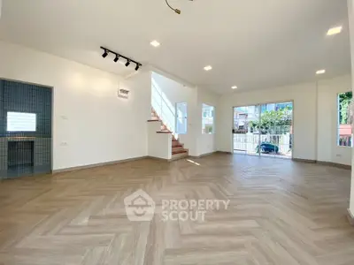 Spacious modern living room with herringbone flooring and large windows
