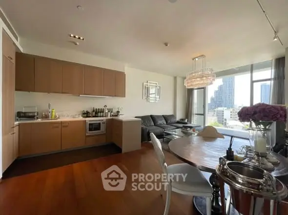 Modern open-layout kitchen and living room with city view and elegant decor.