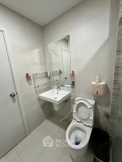 Modern bathroom with sleek fixtures and minimalist design, featuring a wall-mounted sink and toilet.