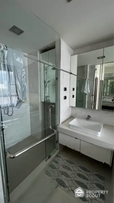 Modern bathroom with glass shower and sleek white sink