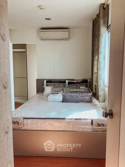 Cozy bedroom with air conditioning and ample natural light, featuring a comfortable bed and stylish decor.
