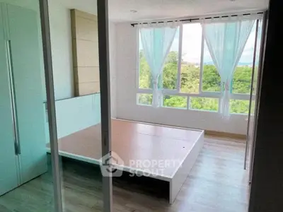 Bright bedroom with large windows and scenic view, featuring modern minimalist design and wooden flooring.