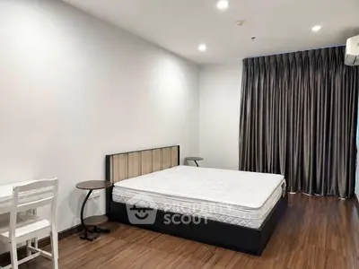 Spacious bedroom with modern furnishings and elegant wooden flooring