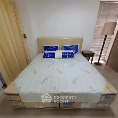 Cozy bedroom with neatly arranged bed and modern decor, perfect for relaxation.