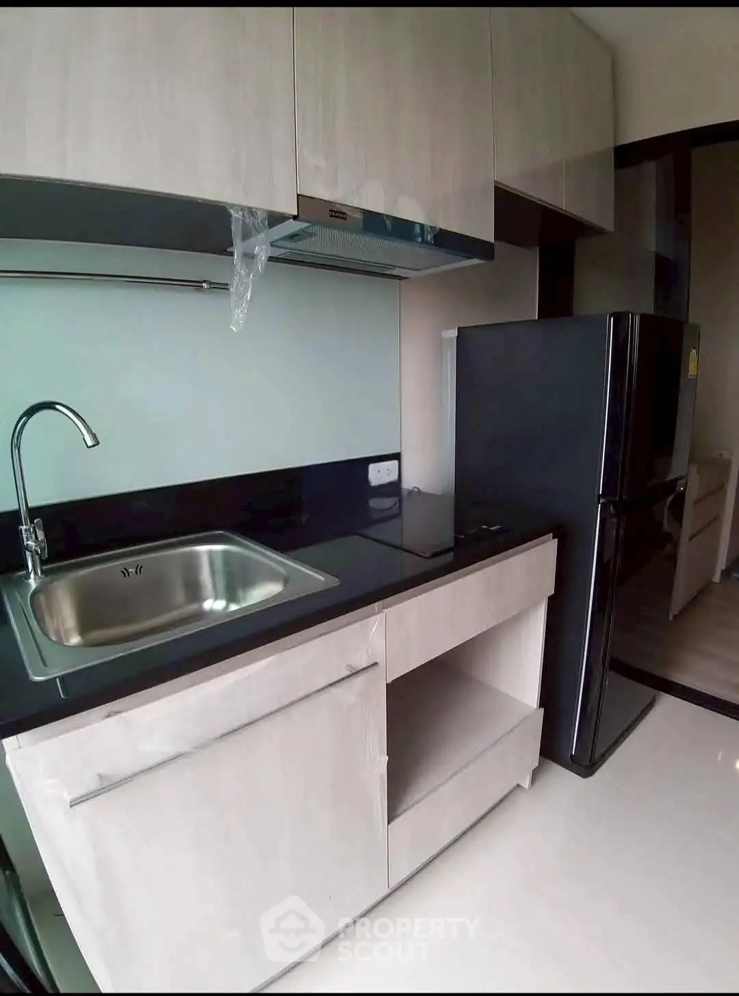Modern kitchen with sleek cabinetry and stainless steel sink in a compact layout.