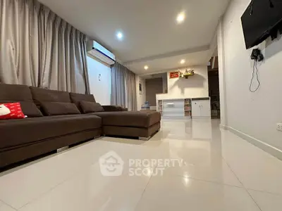 Spacious living room with modern brown sofa and sleek tile flooring