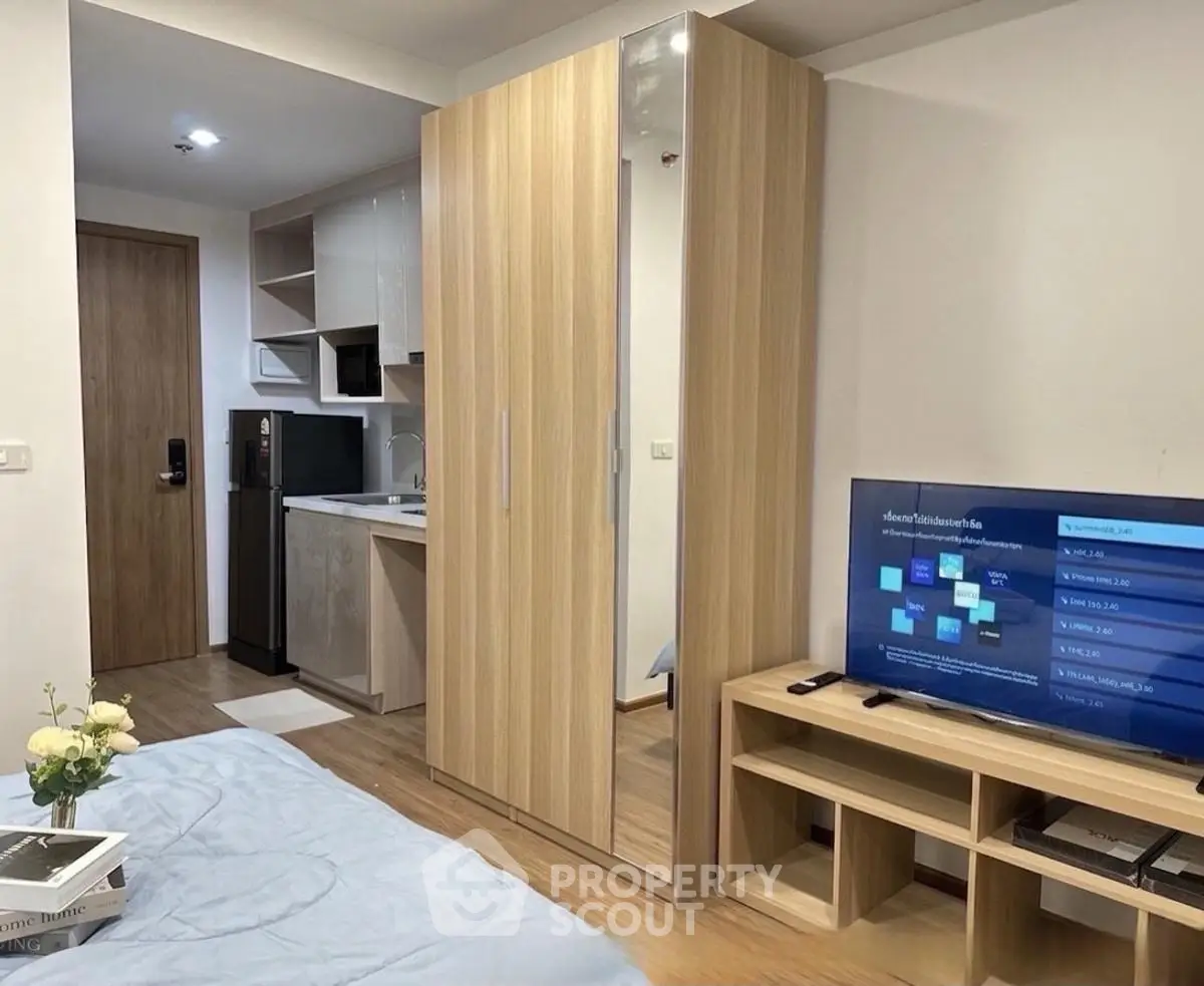 Modern studio apartment with sleek kitchen and cozy living area, perfect for urban living.