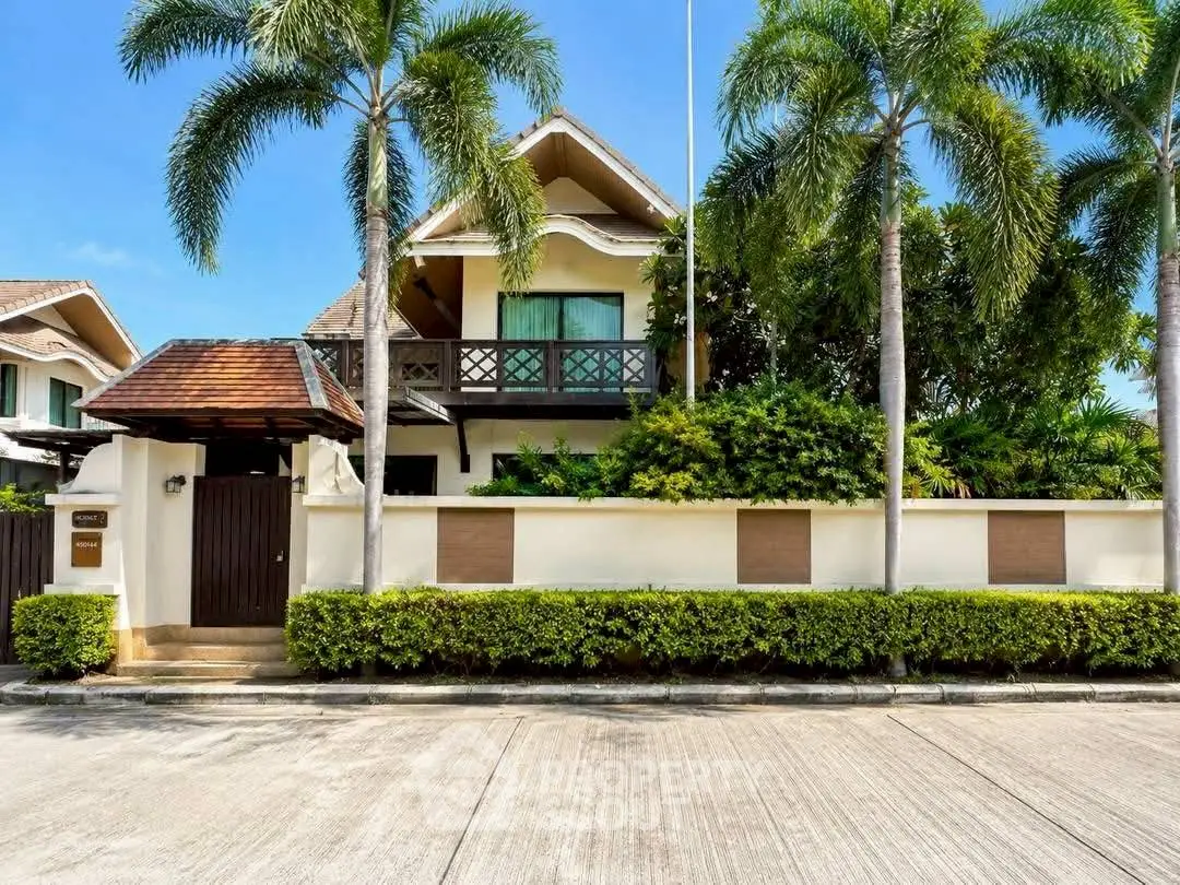 Luxurious tropical villa with lush garden and palm trees, perfect for serene living.