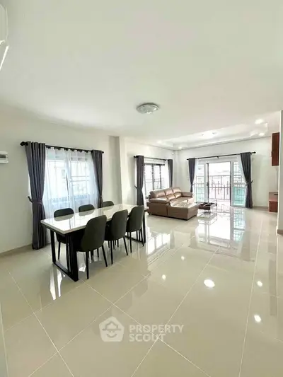 Spacious modern living room with elegant dining area and abundant natural light