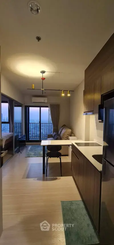 Modern open-layout kitchen and living room with stunning sunset view from balcony.