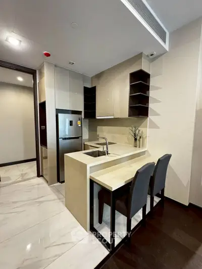 Modern kitchen with sleek design and open layout, featuring a breakfast bar and stainless steel appliances.