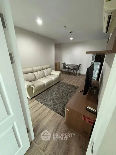 Modern living room with cozy sofa and TV, perfect for relaxation.