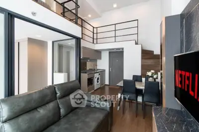 Modern loft apartment with open kitchen, dining area, and stylish living room featuring a leather sofa.