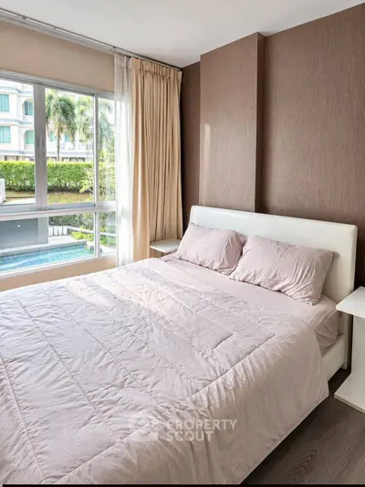 Spacious bedroom with pool view in modern apartment, featuring large windows and elegant decor.