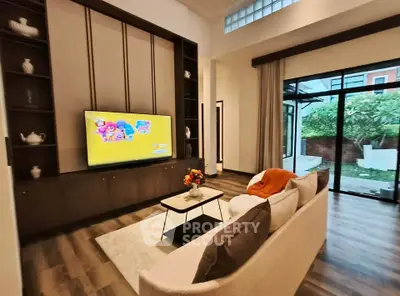 Spacious living room with modern decor and garden view, perfect for family relaxation.