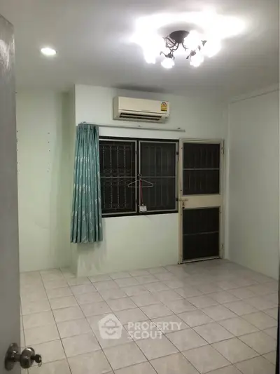 Spacious room with tiled floor and air conditioning, ideal for customization.
