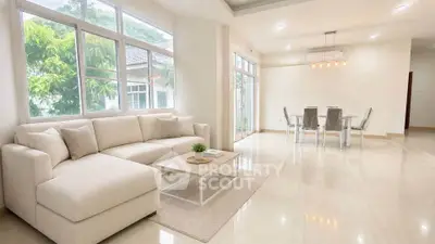 Spacious modern living room with elegant dining area and large windows for natural light.