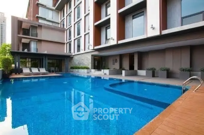 Luxurious modern apartment building with a stunning outdoor pool and stylish design.