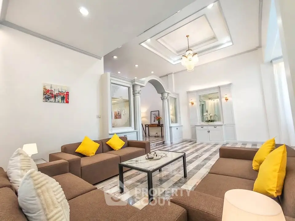 Spacious living room with elegant decor and modern furniture, featuring a stylish ceiling design and ample natural light.