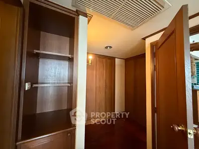 Spacious wooden storage area with built-in shelves and cabinets