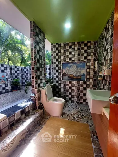 Unique bathroom with artistic tile design and outdoor view, featuring modern fixtures and natural light.