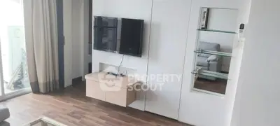 Modern living room with wall-mounted TV and sleek wooden flooring