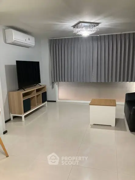 Modern living room with sleek furniture and air conditioning unit