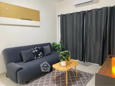 Cozy living room with modern sofa, stylish rug, and elegant curtains.