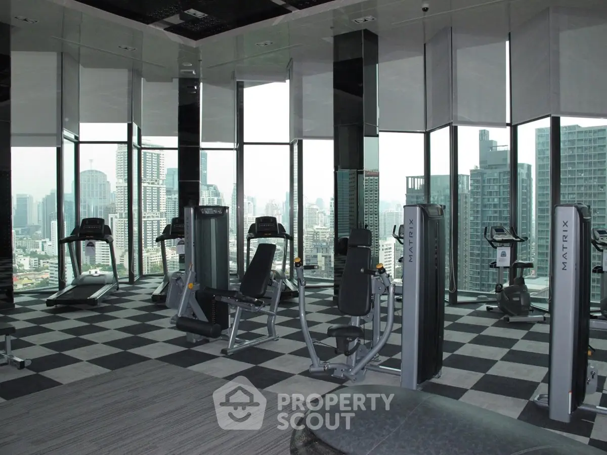 Luxurious high-rise gym with panoramic city views and modern fitness equipment.