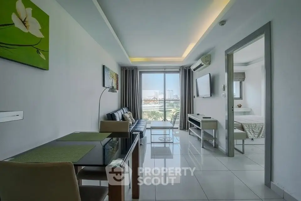 Modern living room with sleek furniture and city view, open layout to bedroom.