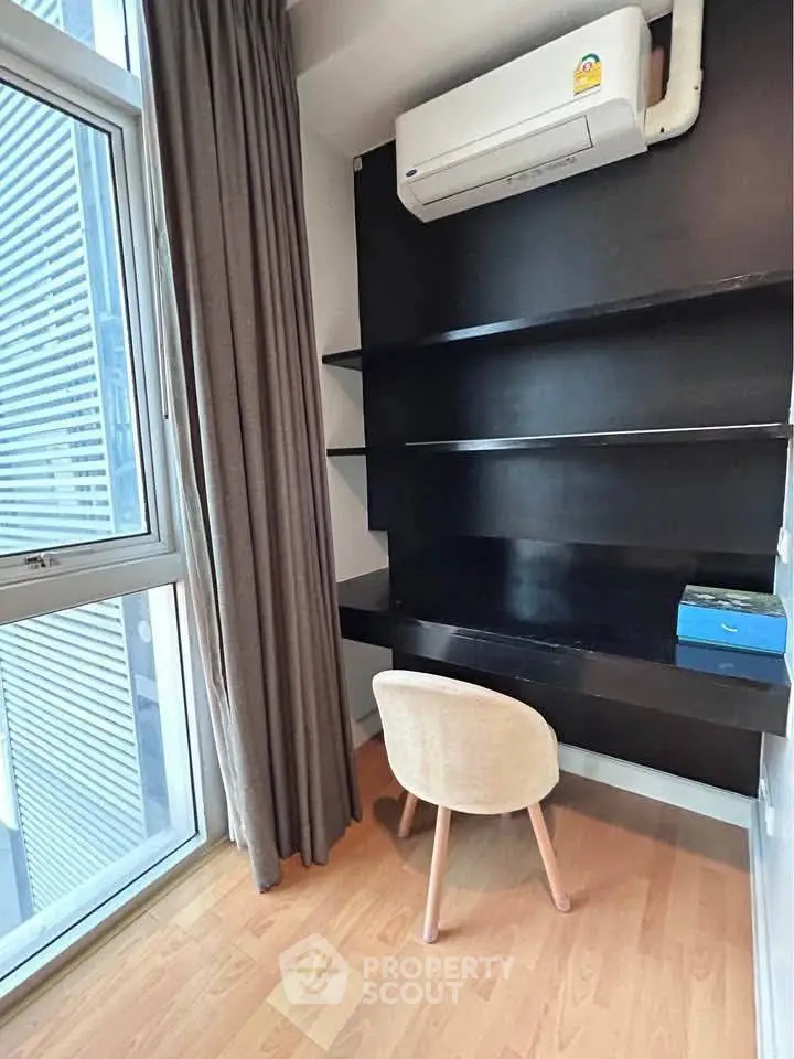 Modern study nook with built-in desk and shelves, featuring large window and air conditioning.